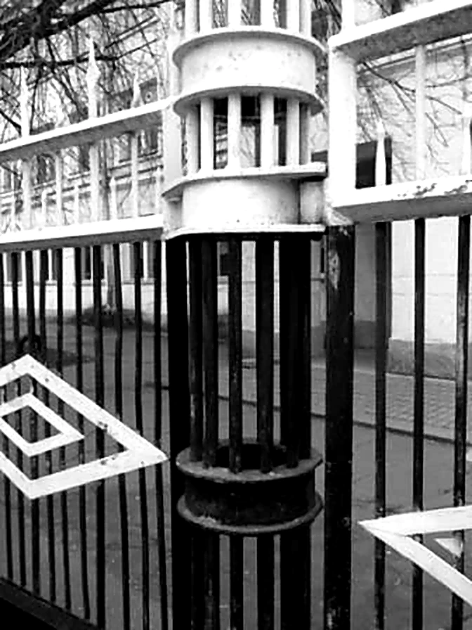 Крупный план оригинального металлического забора, ограждающего территорию школы.