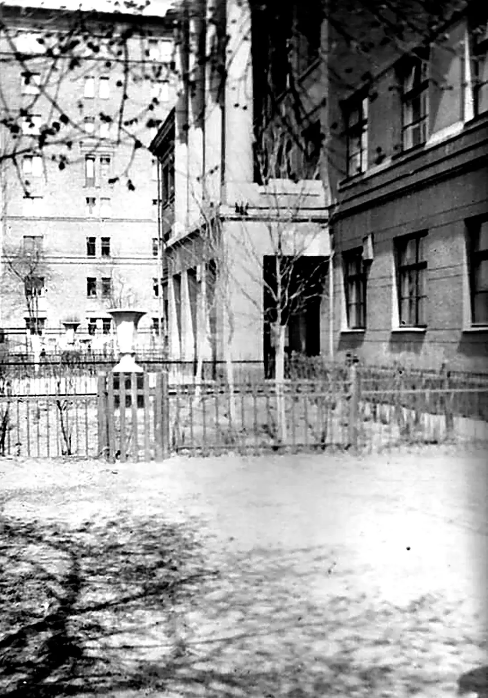 Архивный снимок школьного двора и части фасада здания в советский период.