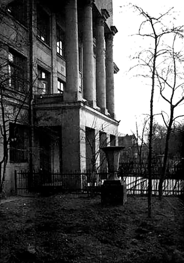 Вид на боковой фасад здания с колоннадой и элементами классической архитектуры.